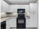 Modern kitchen featuring white cabinets, granite countertops, and black appliances at 3811 Carnegie Ln, Raleigh, NC 27612