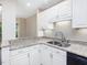 Bright kitchen featuring white cabinets, granite countertops, and a stainless steel sink at 3811 Carnegie Ln, Raleigh, NC 27612