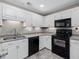 Well-equipped kitchen with white cabinets, black appliances, and granite countertops at 3811 Carnegie Ln, Raleigh, NC 27612