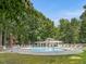 Inviting community pool featuring ample lounge seating, surrounded by lush greenery and a pergola-covered pavilion at 3811 Carnegie Ln, Raleigh, NC 27612