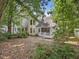 Spacious white house with large windows and a wooden deck, surrounded by lush trees at 3811 Carnegie Ln, Raleigh, NC 27612