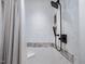 Modern shower with white tiled walls, decorative stone accent, and black shower head at 3811 Carnegie Ln, Raleigh, NC 27612