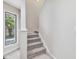 Carpeted staircase with white trim and a window providing natural light at 3811 Carnegie Ln, Raleigh, NC 27612