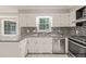Updated kitchen features granite countertops, stainless steel appliances, and white cabinetry at 3821 Whispering Branch Rd, Raleigh, NC 27613