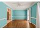 Room with light blue walls, white trim, and wood floors opens to the kitchen at 3821 Whispering Branch Rd, Raleigh, NC 27613