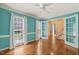 Sunlit room featuring two windows, white trim, and double french doors to another room at 3821 Whispering Branch Rd, Raleigh, NC 27613
