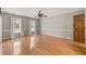 Spacious main bedroom with hardwood floors, neutral paint, ceiling fan, and natural light from two large windows at 3821 Whispering Branch Rd, Raleigh, NC 27613