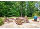 Backyard fire pit and outdoor seating area surrounded by beautiful landscaping and lush greenery at 401 Westbury Dr, Chapel Hill, NC 27516