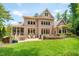 Expansive backyard featuring a patio with outdoor kitchen, fire pit, and lush green lawn at 401 Westbury Dr, Chapel Hill, NC 27516