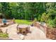 Outdoor dining area with built in grill surrounded by beautiful landscaping and lush greenery at 401 Westbury Dr, Chapel Hill, NC 27516