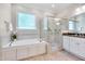Bright bathroom featuring a soaking tub, a glass enclosed shower, and double vanity sinks at 401 Westbury Dr, Chapel Hill, NC 27516