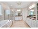 Bathroom featuring a soaking tub, glass-enclosed shower, and double vanities at 401 Westbury Dr, Chapel Hill, NC 27516