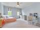 Light blue bedroom with neutral carpet, two windows with bright light, and a ceiling fan at 401 Westbury Dr, Chapel Hill, NC 27516