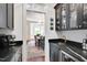 Convenient butler's pantry featuring sleek dark cabinetry, granite countertops, and stylish gold hardware at 401 Westbury Dr, Chapel Hill, NC 27516