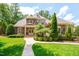 Stunning stone home with lush landscaping, a winding walkway, and a manicured lawn in a suburban setting at 401 Westbury Dr, Chapel Hill, NC 27516