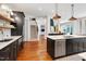 Open kitchen features an island with seating, stainless appliances, and hardwood floors at 401 Westbury Dr, Chapel Hill, NC 27516