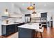 Modern kitchen boasts marble counters, dark cabinets, custom vent hood, and stainless-steel appliances at 401 Westbury Dr, Chapel Hill, NC 27516