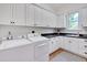 Laundry room with white cabinets, countertop, and a washer and dryer at 401 Westbury Dr, Chapel Hill, NC 27516