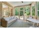 Relaxing sunroom with brick accents, ample seating, and serene views of the outdoors at 401 Westbury Dr, Chapel Hill, NC 27516