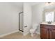 This bathroom features a standing shower, toilet, dark cabinets, and a sink with mirror and lights at 410 Stranraer Ct, Fuquay Varina, NC 27526