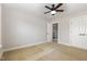This is a carpeted bedroom featuring a ceiling fan, a closet, and a door leading to another room at 410 Stranraer Ct, Fuquay Varina, NC 27526