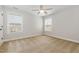 A well-lit bedroom featuring neutral walls, carpet floors, a ceiling fan, and a large window at 410 Stranraer Ct, Fuquay Varina, NC 27526