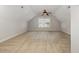 A bright bonus room with neutral paint, carpet flooring, vaulted ceilings, and a large window at 410 Stranraer Ct, Fuquay Varina, NC 27526