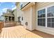 View of a wood deck attached to a house featuring neutral walls, a white door and windows at 410 Stranraer Ct, Fuquay Varina, NC 27526