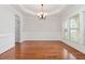 Formal dining room with gleaming wood floors, wainscoting, crown molding and large windows for great natural light at 410 Stranraer Ct, Fuquay Varina, NC 27526