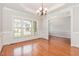 Sun-lit dining room featuring wood floors, large windows and classic chandelier, ideal for Gathering gatherings at 410 Stranraer Ct, Fuquay Varina, NC 27526