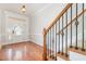 Foyer features hardwood floors, a staircase with decorative iron spindles, and a glass front door at 410 Stranraer Ct, Fuquay Varina, NC 27526