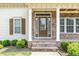 Inviting front entrance with stone accents, a glass door, and beautifully landscaped bushes at 410 Stranraer Ct, Fuquay Varina, NC 27526
