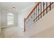 Bright hallway featuring carpet, stairs with wood and iron railing, and a window providing natural light at 410 Stranraer Ct, Fuquay Varina, NC 27526