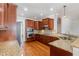 A kitchen featuring wooden cabinets, granite countertops, and stainless steel appliances at 410 Stranraer Ct, Fuquay Varina, NC 27526