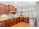 Cherry kitchen with stainless appliances, tile backsplash, and views into living area at 410 Stranraer Ct, Fuquay Varina, NC 27526