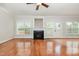 Large living room with fireplace, hardwood floors, ceiling fan, windows, and white trim throughout at 410 Stranraer Ct, Fuquay Varina, NC 27526