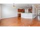 Hardwood floors flowing from open living space to kitchen area with a breakfast bar and ample cabinet space at 410 Stranraer Ct, Fuquay Varina, NC 27526