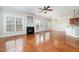 Open-concept living room featuring hardwood floors, fireplace, many windows, and access to the kitchen at 410 Stranraer Ct, Fuquay Varina, NC 27526