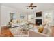 Bright living room with fireplace, plush rug, and stylish white couches with gold accents at 410 Stranraer Ct, Fuquay Varina, NC 27526