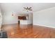 Open layout showcasing living room with hardwood floors and a ceiling fan, seamlessly connecting to the kitchen at 410 Stranraer Ct, Fuquay Varina, NC 27526
