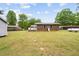 Expansive backyard with a brick house, white porch, storage shed, and ample green space at 410 W Tenth St, Siler City, NC 27344