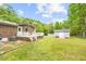 Well-manicured backyard featuring a brick house, deck, storage shed, and green lawn at 410 W Tenth St, Siler City, NC 27344