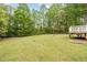 Lush backyard with a well-maintained lawn, a deck with white railings, and mature trees at 410 W Tenth St, Siler City, NC 27344