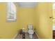 Small yellow bathroom with a tile floor and a toilet next to a window at 410 W Tenth St, Siler City, NC 27344