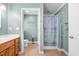 Well-lit bathroom featuring a shower with stylish curtain and a vanity with wood cabinets at 410 W Tenth St, Siler City, NC 27344