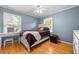 Bright bedroom with a ceiling fan, two windows, and a comfortable bed with inviting linens at 410 W Tenth St, Siler City, NC 27344