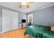 Bedroom featuring a ceiling fan, hardwood floors and an entertainment center with TV at 410 W Tenth St, Siler City, NC 27344
