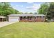 Charming brick home featuring a metal roof and well-manicured lawn at 410 W Tenth St, Siler City, NC 27344