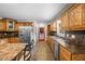 Traditional eat-in kitchen boasts wooden cabinetry, granite countertops, and stainless steel appliances at 410 W Tenth St, Siler City, NC 27344