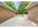 Outdoor patio between brick walls, featuring a concrete floor and a gated fence in the background at 410 W Tenth St, Siler City, NC 27344